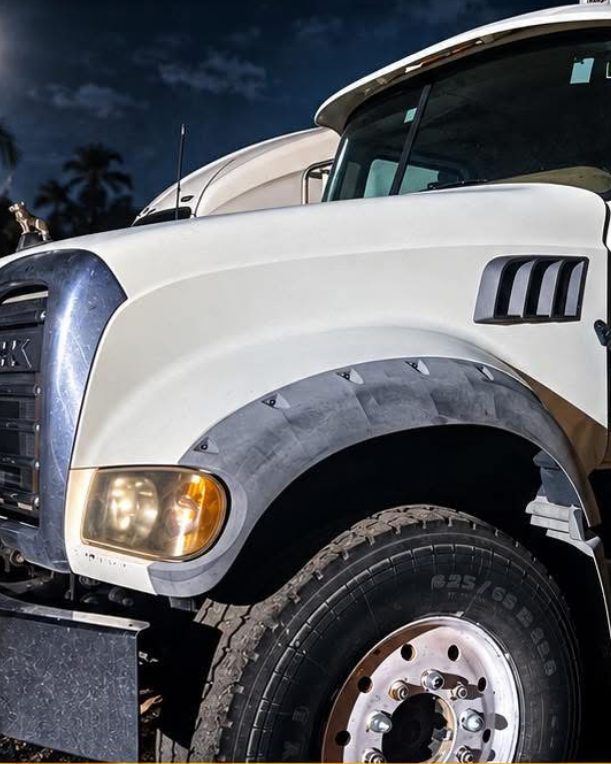 A B.O.S. Trucking & Site white Mack tri-axle dump truck parked at the company yard in Fort Myers, Florida